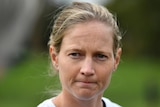 An Australian female cricket looks toward her right as she answers a question at a media conference.