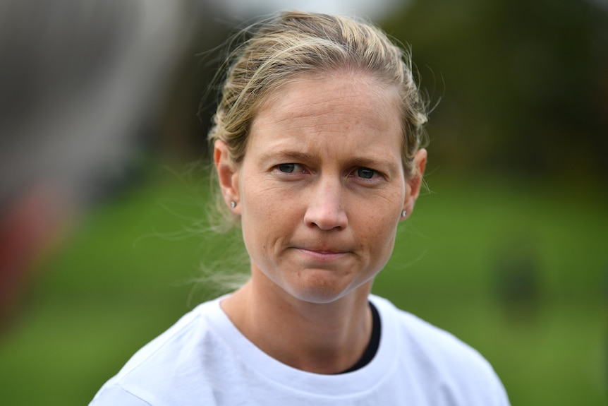 An Australian female cricket looks toward her right as she answers a question at a media conference.