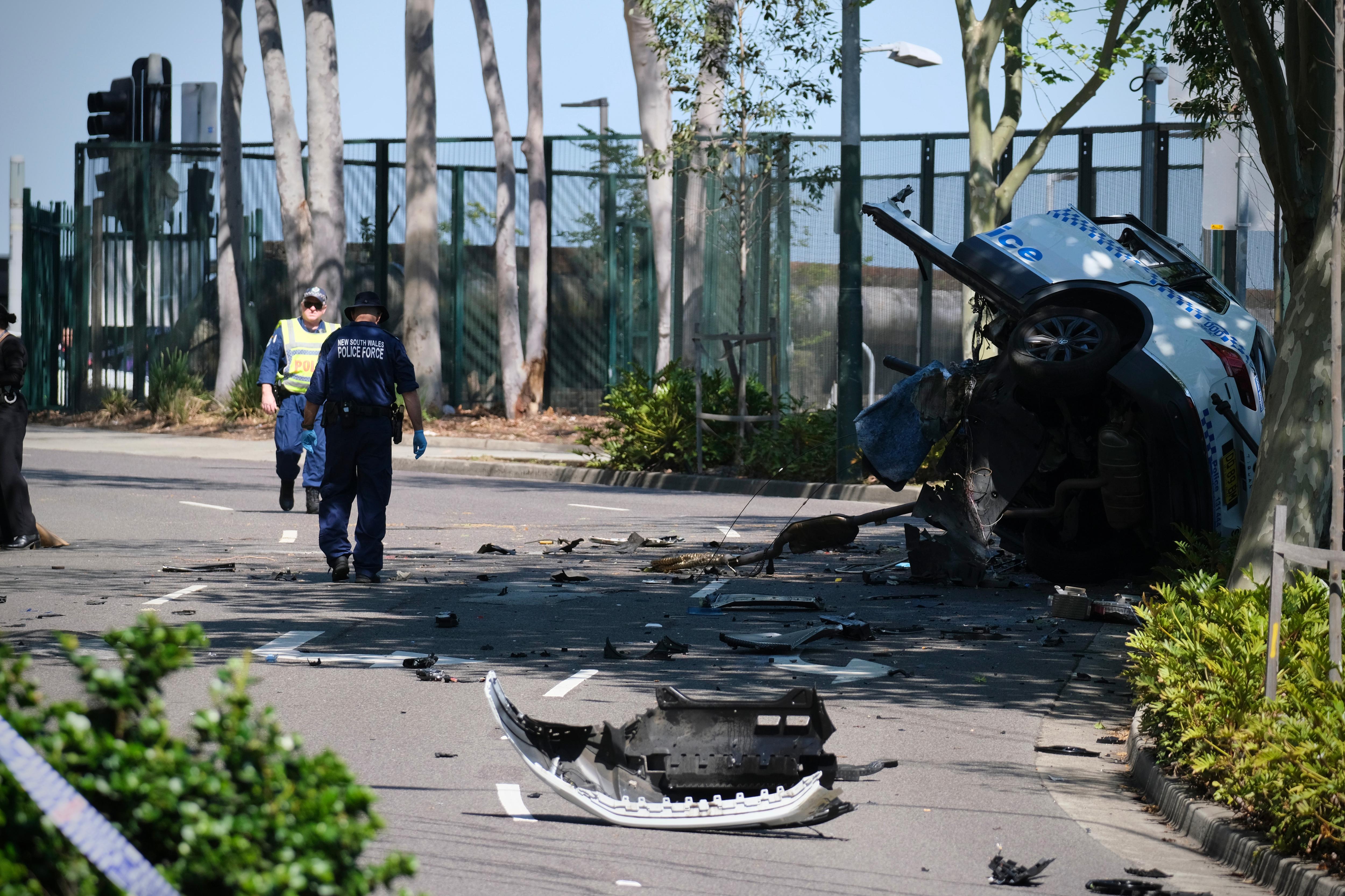 police officers near a turned over police car that crashed killing a young police officer