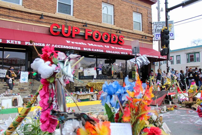 A shop called 'Cup Foods' with flowers outside the entrance