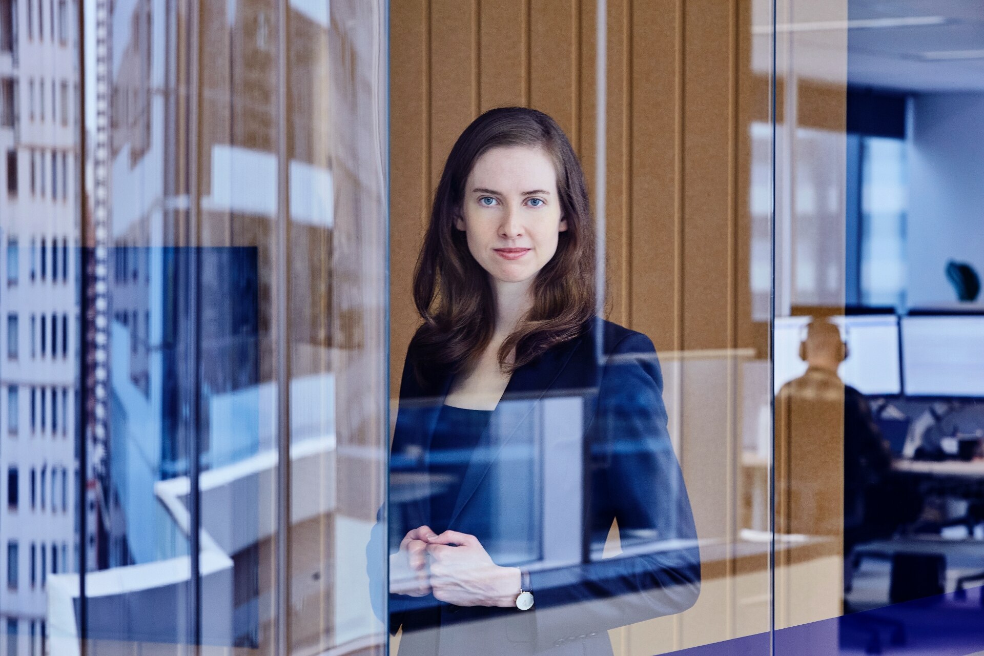 a woman behind a glass staring into the camera