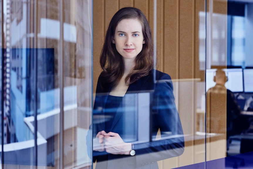 a woman behind a glass staring into the camera