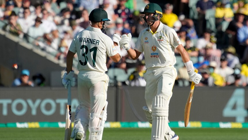 Two Australian male batters congratulate each over during the second Ashes Test in Adelaide.