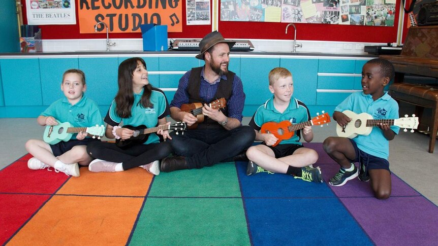 CJ Shaw plays ukulele with students.