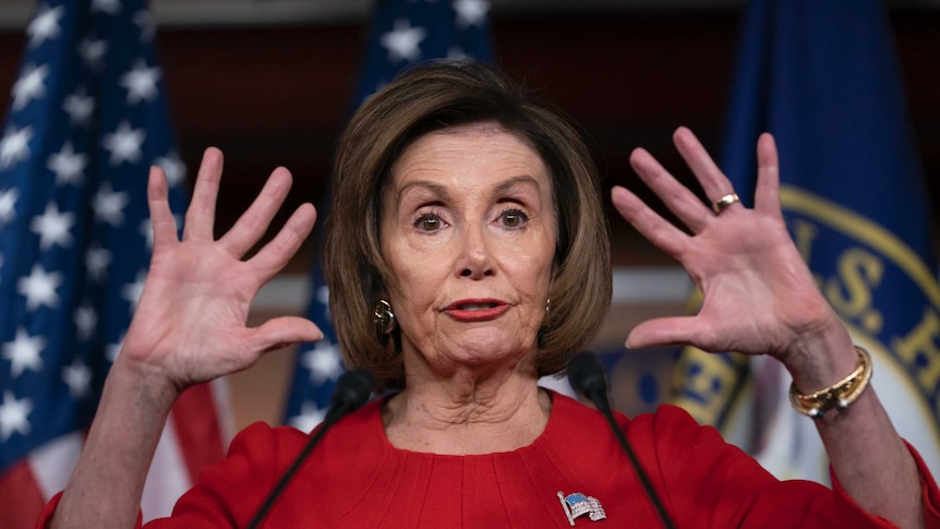 Nancy Pelosi holds up both hands with fingers spread.