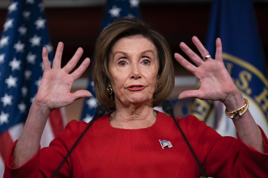 Nancy Pelosi holds up both hands with fingers spread.