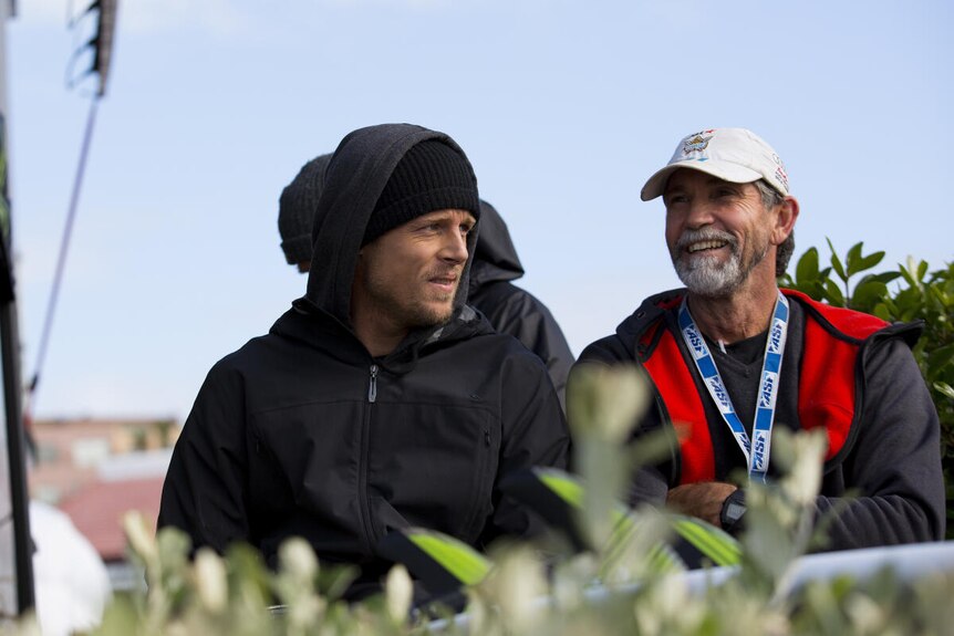 mick fanning and phil mcnamara talking at a surfing competition