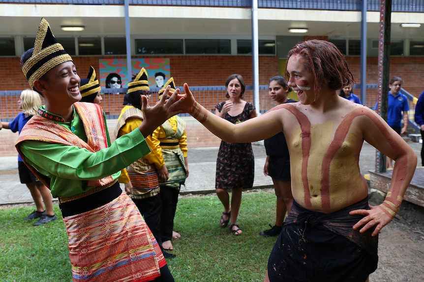 Indonesian and Aboriginal student shake hands and smile