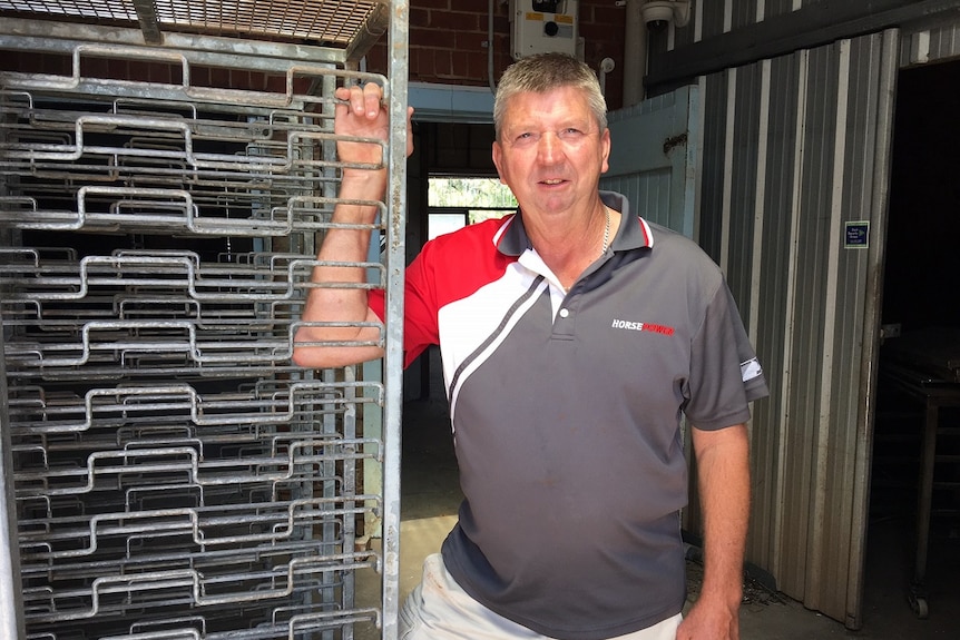 Man stands with bakery racks