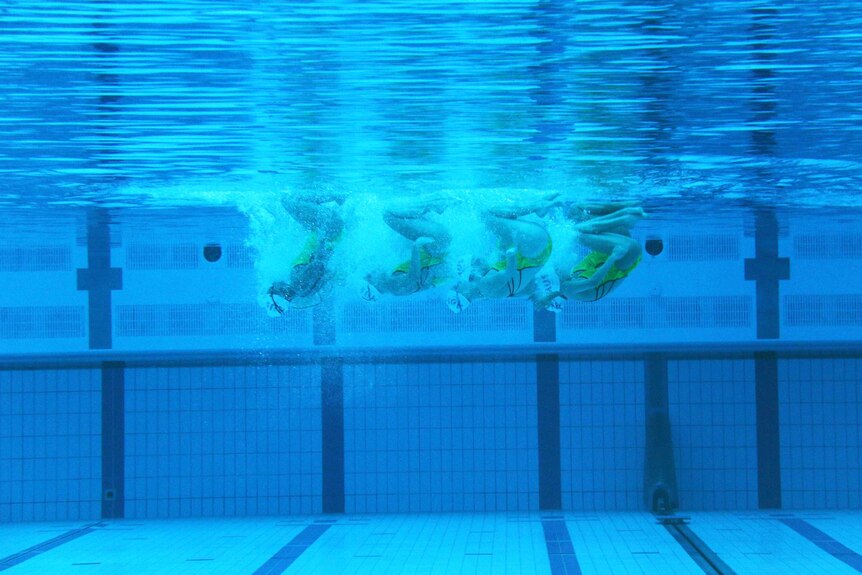 View from underwater of the synchronised swimming team.