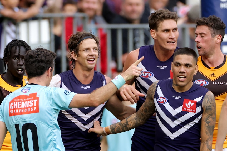 Nat Fyfe smiling and surrounded by teammates 
