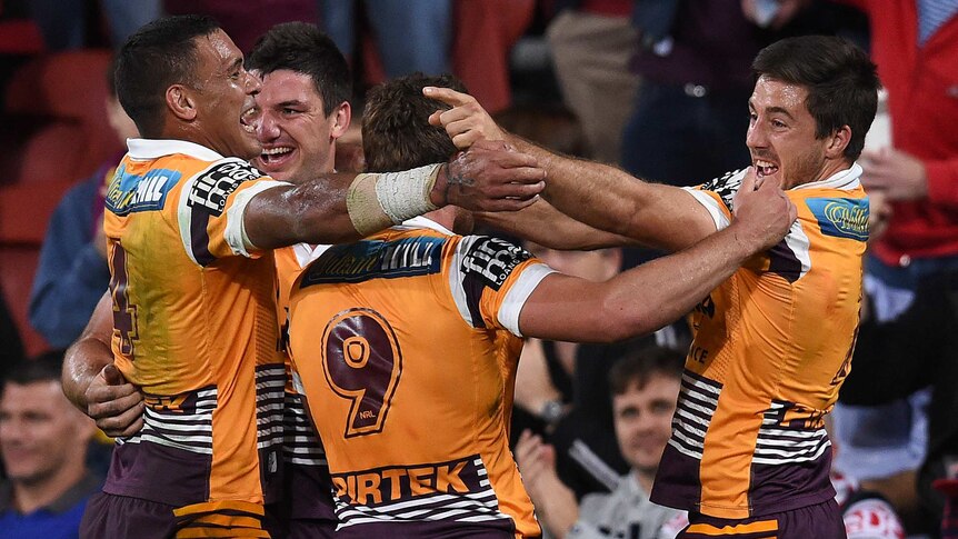 Brisbane Broncos players celebrate a try during their preliminary final against the Roosters.