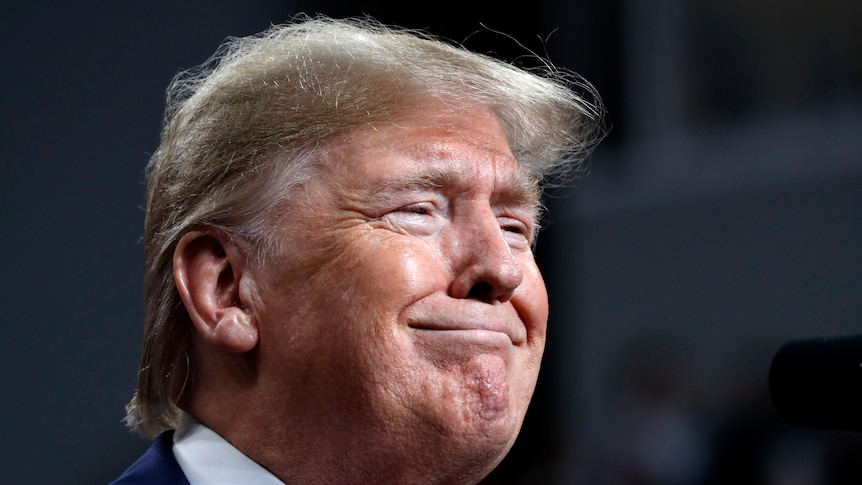 President Donald Trump smiles while speaking at a campaign rally.