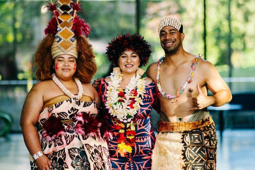 Two women and a man dressed in traditional Samoan attire