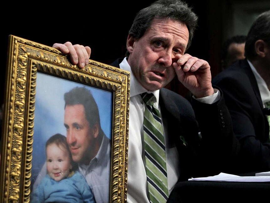 Neil Heslin holds a picture of himself with son,  Jesse Lewis.