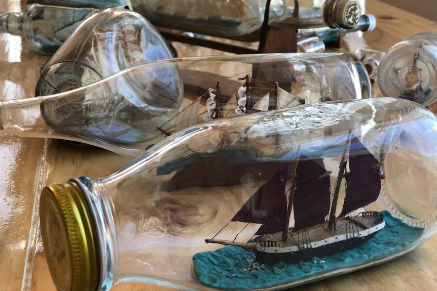 Several bottles with boats inside them