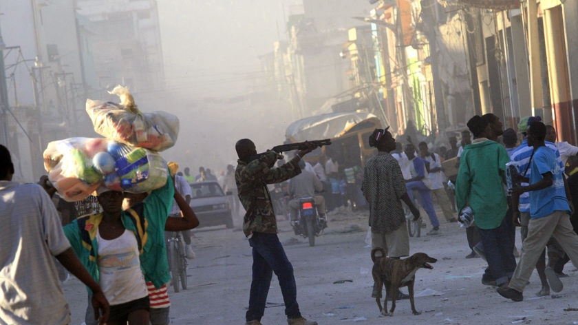 A man points a gun at a crowd in downtown Port-au-Prince in Haiti