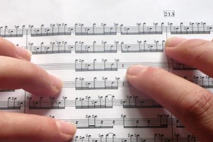 Fingers touching sheet music.