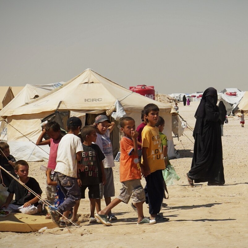 A group of kids in a dusty camp.