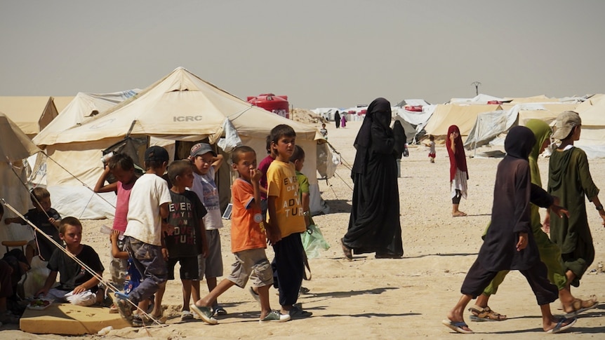 A group of kids in a dusty camp.