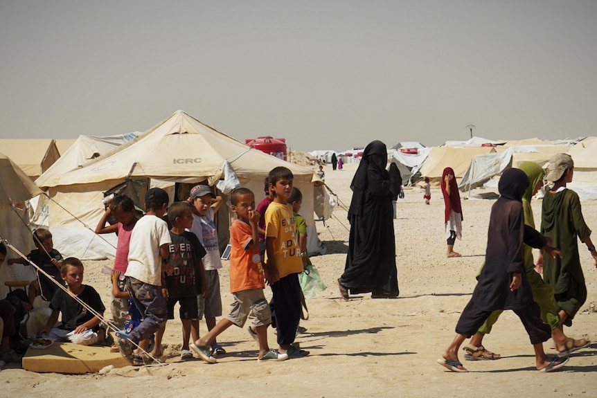 A group of kids in a dusty camp.