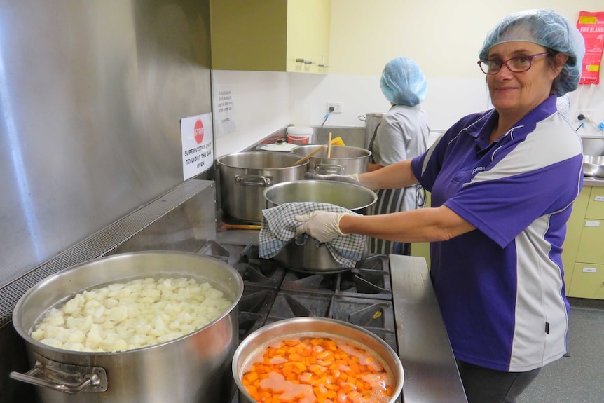 Volunteer Tanya Langdon cooking vegetables on the stove at the Waterbridge Food Co-Op in Gagebrook, Tasmania