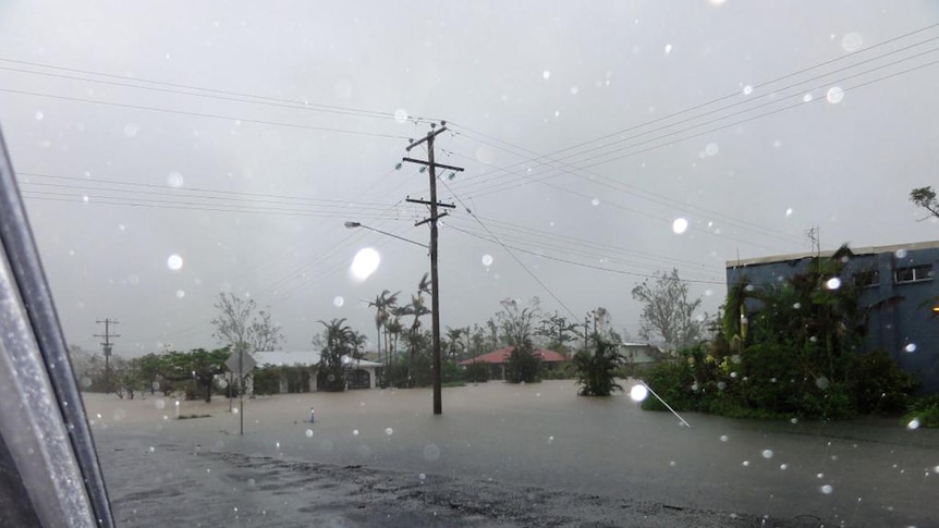 A car driving through flooded Cardwell, in north Queensland