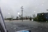 A car driving through flooded Cardwell, in north Queensland