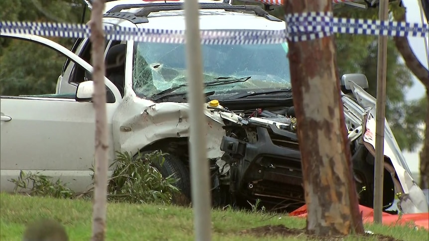 A car with a crumpled front and a hole in its windscreen, with police tape in front.