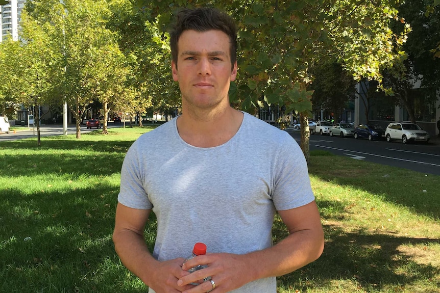 Former Essendon player Brent Prismall stands in a inner-city park.