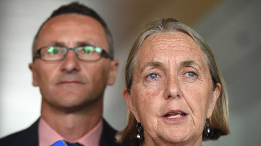 The Greens senator Lee Rhiannon (R) and leader Richard Di Natale stands behind her.