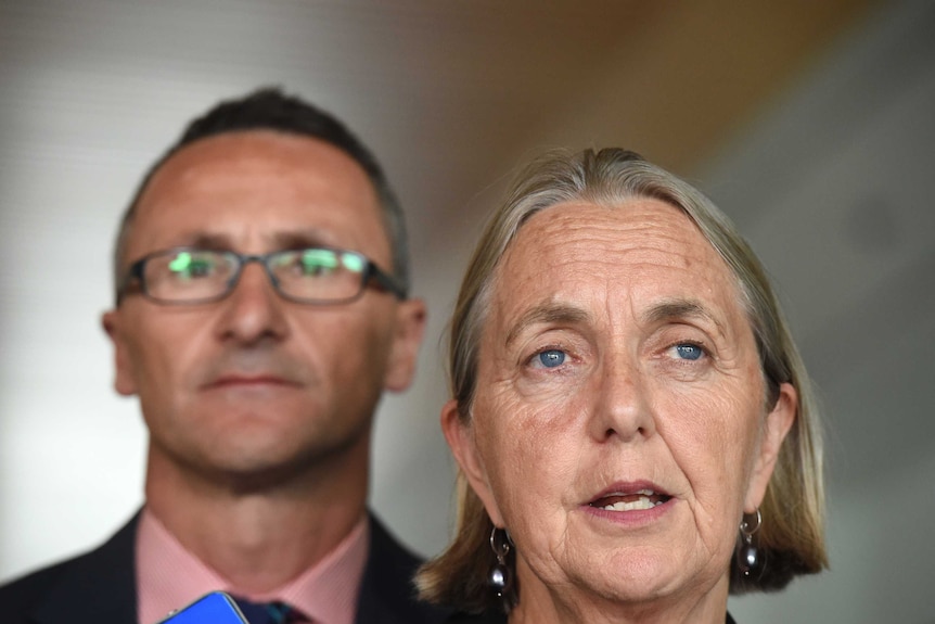 The Greens senator Lee Rhiannon (R) and leader Richard Di Natale stands behind her.