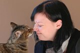 A customer touches noses with a cat.