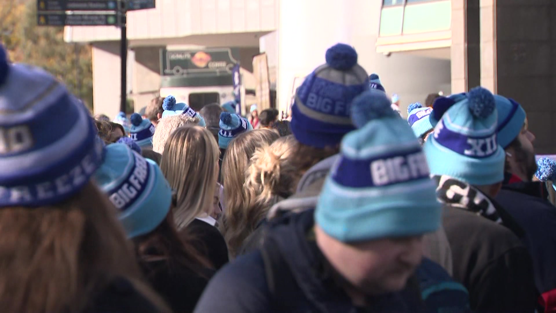 Un primer plano de una multitud de personas, la mayoría con sombreros azules con las palabras 