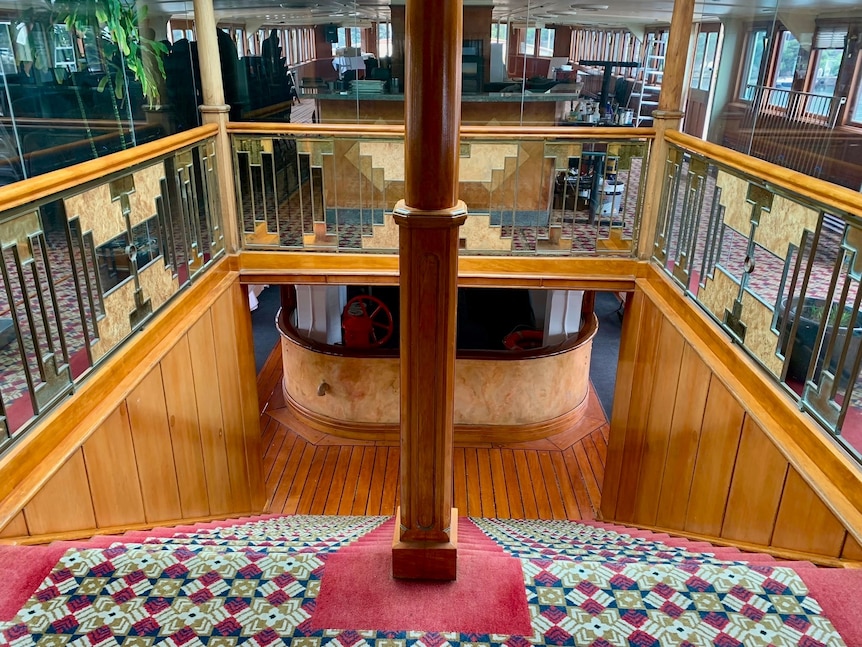 The interior of a steam ferry. Stairs lead down to a lower level. 