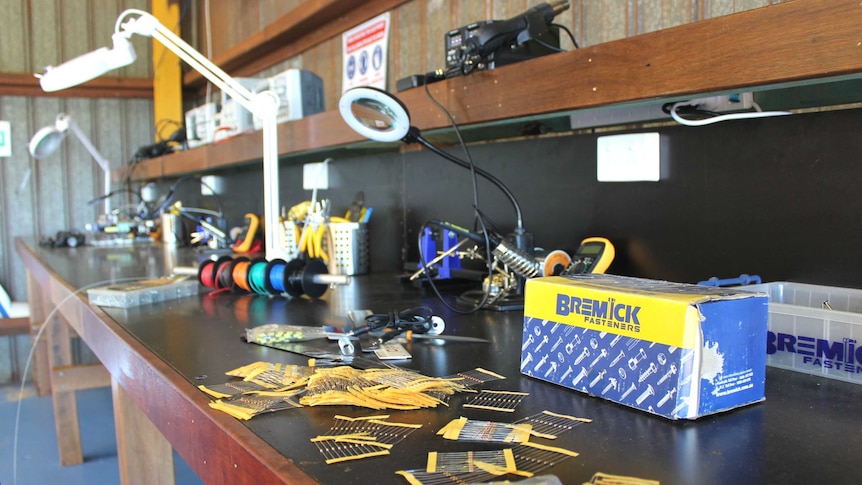 A work bench is filled with tools and equipment used to make robotics