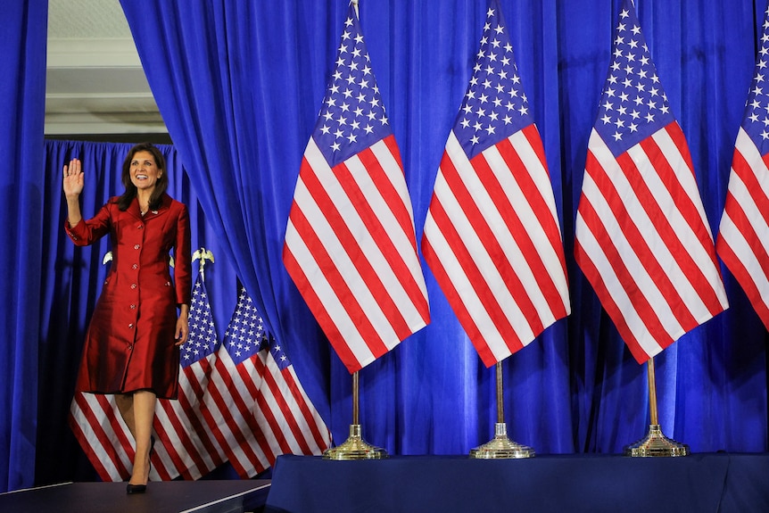 Nikki Haley walks on stage smiling and waving in South Carolina.
