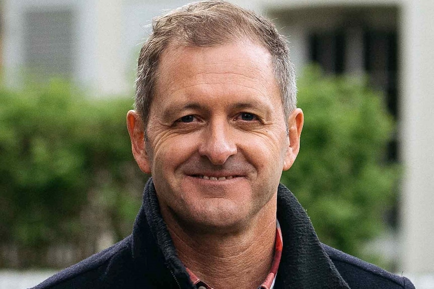 A medium close-up of a man smiling.