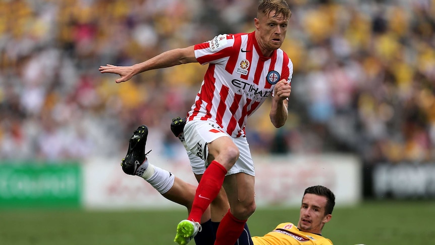 Damien Duff of Melbourne City contests the ball against Jacob Poscoliero