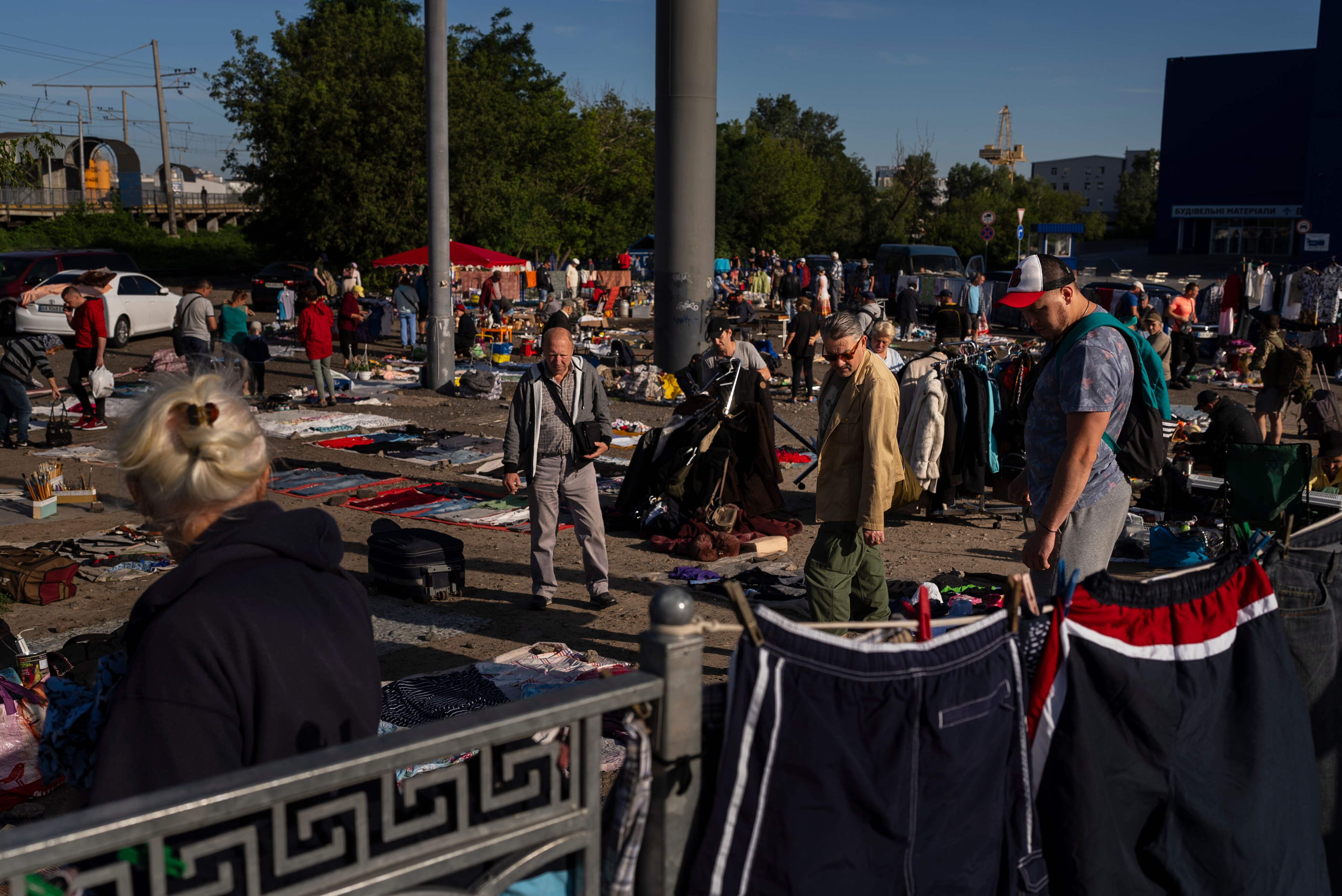 Several people stand around looking at various items laid out on the ground.