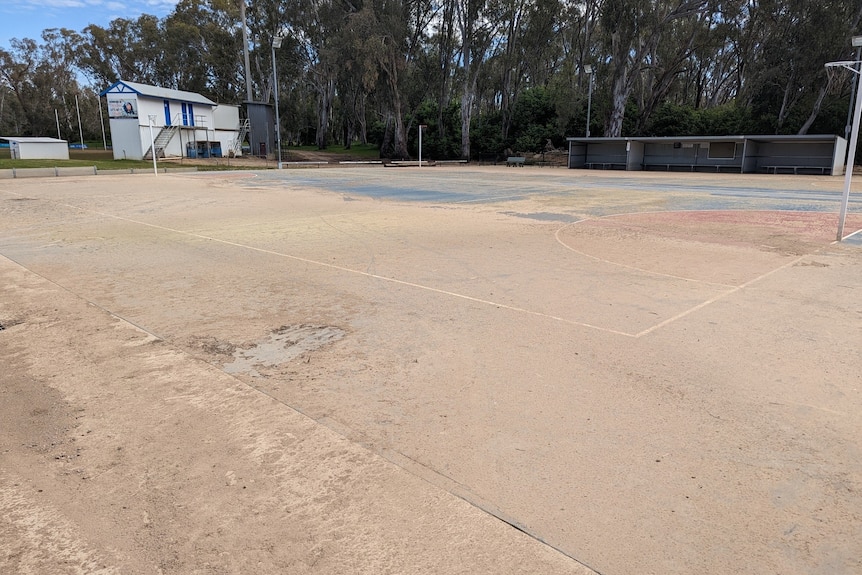 A netball court covered in dry mud