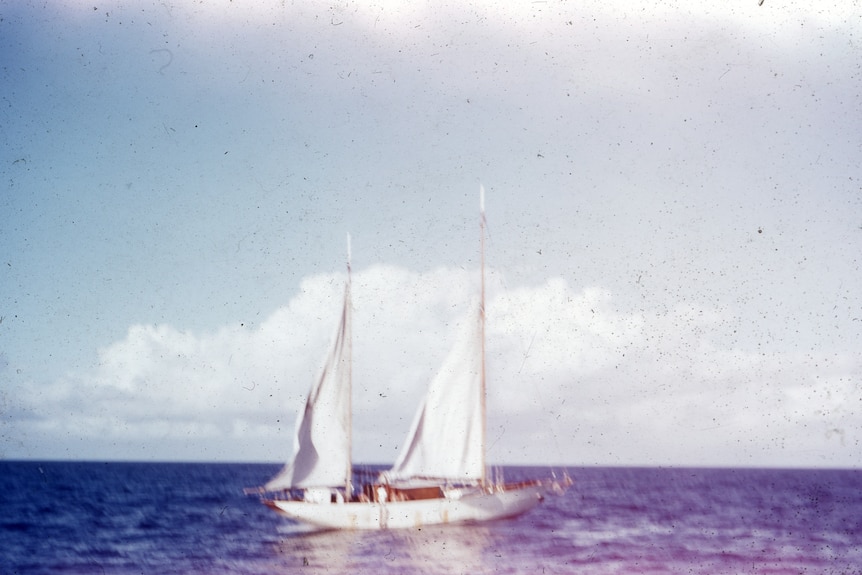 An old photo of a boat on the ocean. The boat is in distress.