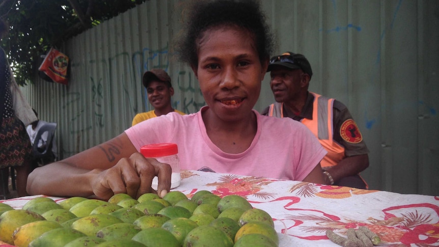 Lois Phillip poses in front of betel nuts laid on a piece of cloth.