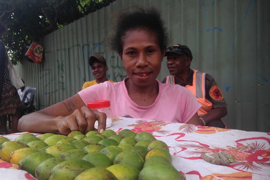 Lois Phillip poses in front of betel nuts laid on a piece of cloth.