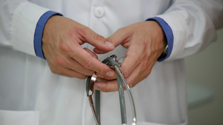 Hands of a doctor holding a stethoscope.