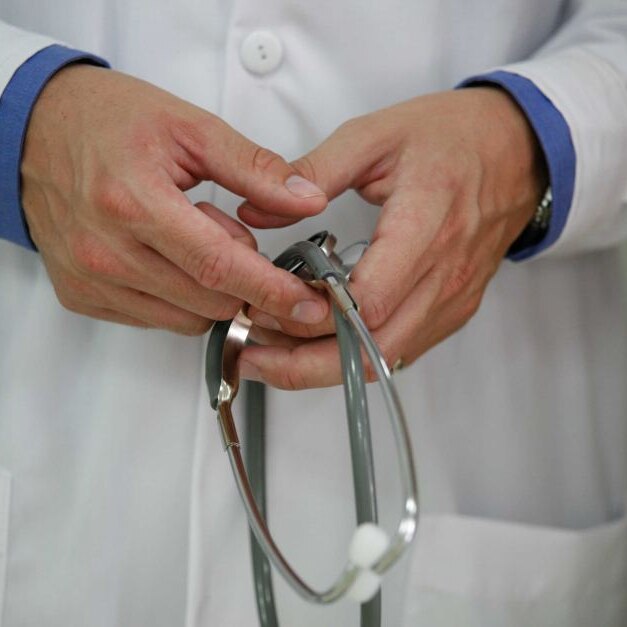 Closeup of a doctor holding a stethoscope.