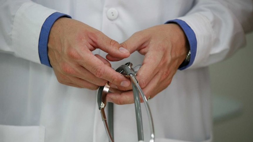 A doctor's hands in a white coat holding a stethoscope