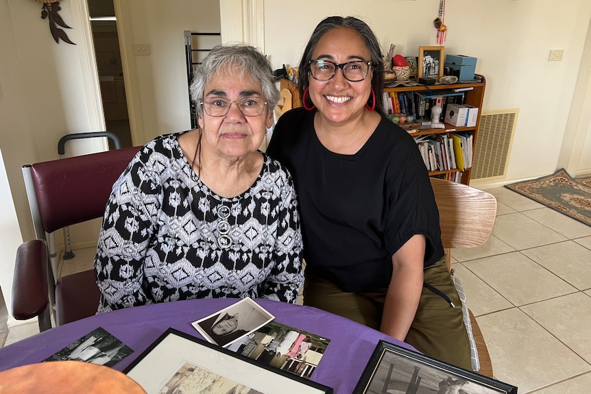 A mother and daughter in a home smiling at the camera