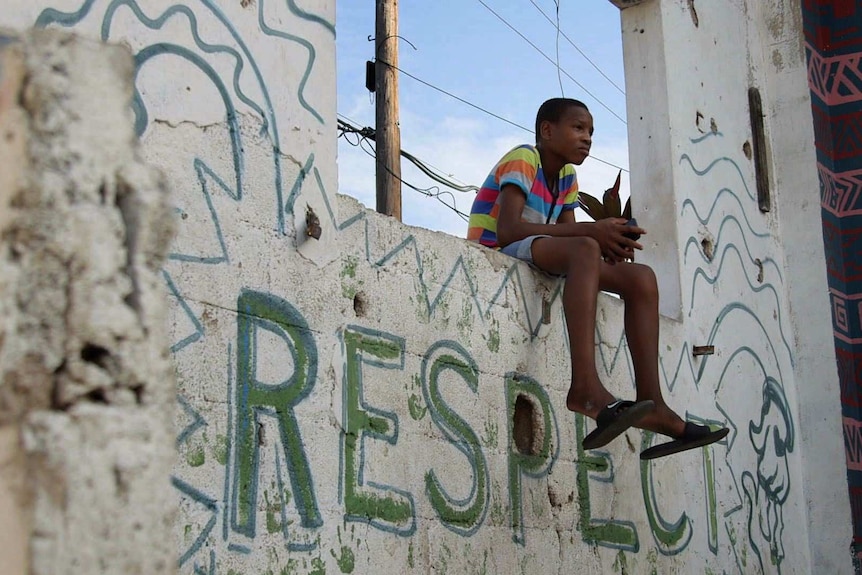 "Yard art" murals that fill the streets of Kingston illustrate the social struggles young people face.