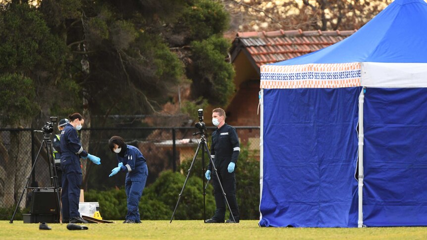 Victorian Police forensic officers at the scene where a woman's body was found on a soccer field in Melbourne's north.